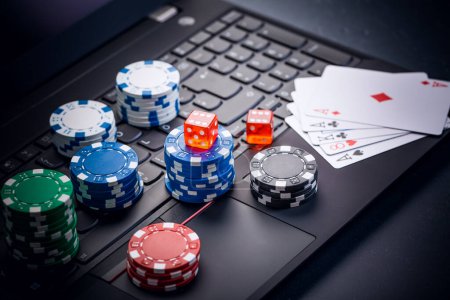 Online-Poker. Chips, Karten und Würfel in der Nähe der Tastatur. Wettservice im Internet. Auf einer Webseite zocken und Geld gewinnen. Poker zu Hause online spielen.