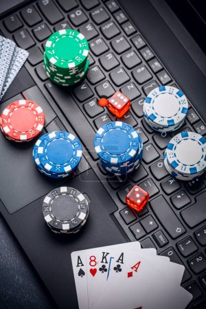 Online-Poker. Chips, Karten und Würfel in der Nähe der Tastatur. Wettservice im Internet. Auf einer Webseite zocken und Geld gewinnen. Poker zu Hause online spielen.