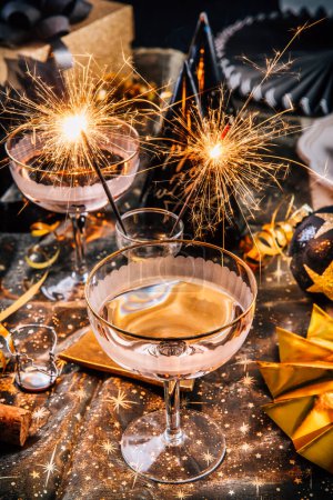 Foto de Feliz Año Nuevo - dos copas de champán con espumoso en la mesa de fiesta decorada - Imagen libre de derechos