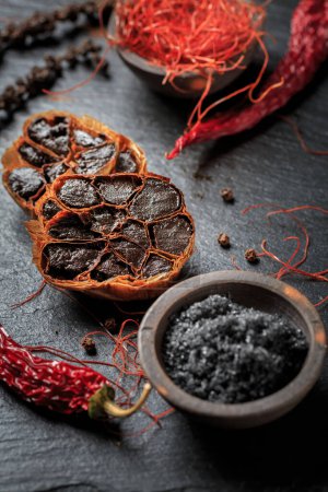 Photo for Organic Fermented Black Garlic with  Himalayan black rock salt  and chili threads - Royalty Free Image