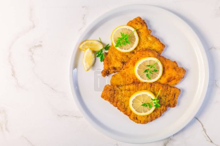 Téléchargez les photos : Breaded fish, baked and served with lemon. Common dab, edible flatfisch (Limanda limanda) - en image libre de droit