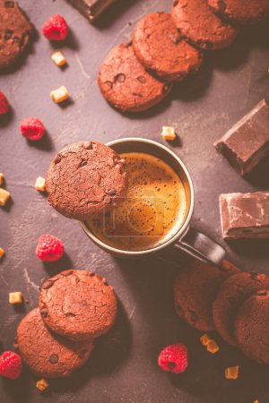 Foto de Cup of hot coffee and chocolate cookies for breakfast  or snack on wooden table - Imagen libre de derechos