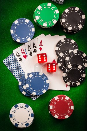 Playing cards, dice and poker chips , casino poker chips on green background