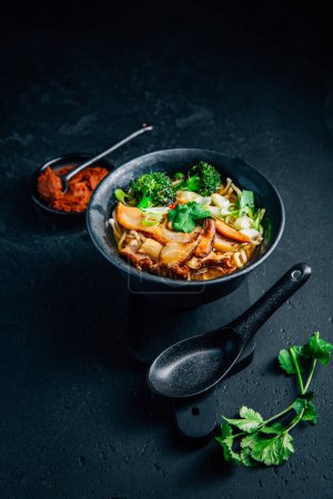 Téléchargez les photos : Vegan miso or ramen soup with mushrooms and vegetables on black background - en image libre de droit