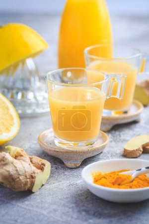 Photo for Homemade turmeric lemon ginger shots in small glasses - Royalty Free Image