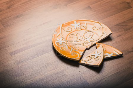 Photo for Broken ceramic plate on wooden floor - Royalty Free Image