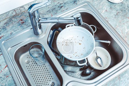 Photo for Dishwashing - pile of dirty dishes in kitchen sink - Royalty Free Image