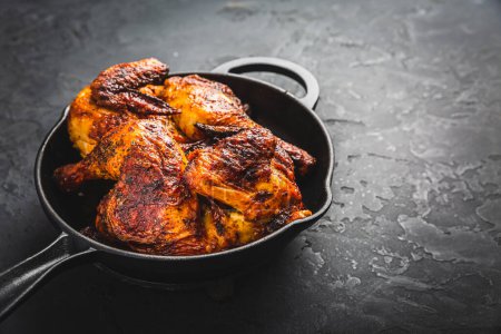 Foto de Roasted half chicken in pan on black background - Imagen libre de derechos
