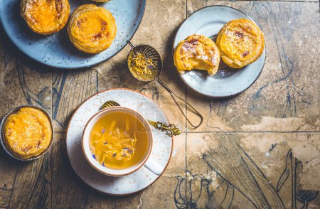 Foto de Pastel de nata con taza de té de hierbas, huevo dulce y hojaldre de Portugal - Imagen libre de derechos