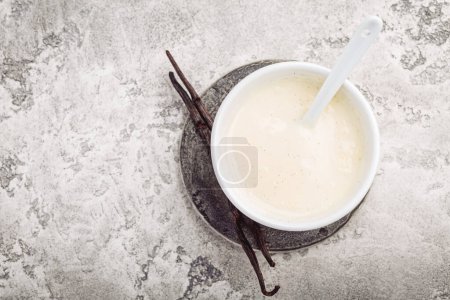 Téléchargez les photos : Homemade vanilla sauce in small bowl on grey background - en image libre de droit