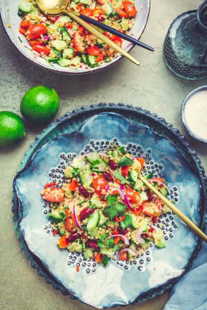 Téléchargez les photos : Salade saine de quinoa aux tomates fraîches, concombres, oignons et coriandre - en image libre de droit
