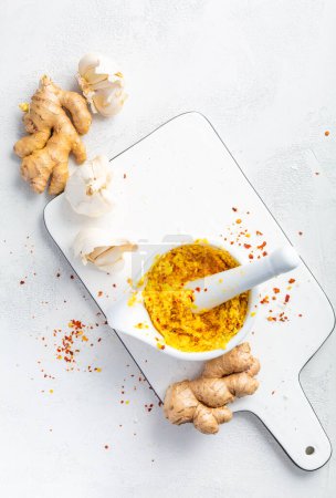 Téléchargez les photos : Pâte d'ail et gingembre frais maison ou purée d'Adrak Lahsun dans un bol en céramique sur fond blanc. Cuisine asiatique - en image libre de droit