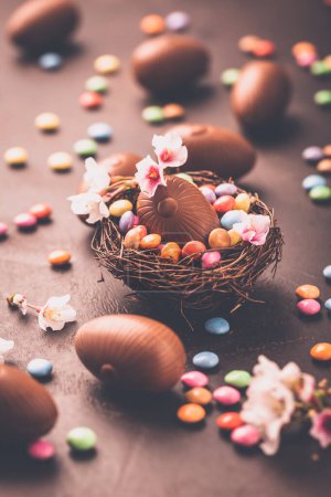 Foto de Dulce Pascua: huevos de chocolate y frijoles de chocolate coloridos en el nido de aves - Imagen libre de derechos