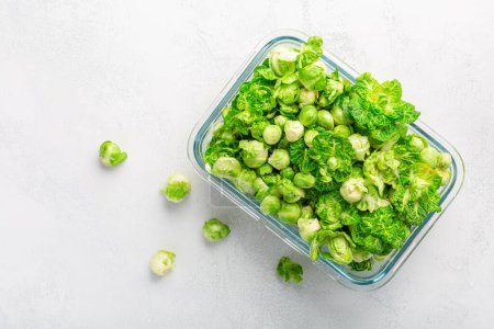 Foto de Fresh  organic green brussels sprouts and small winter cabbage vegetable in glass container, ready to freeze - Imagen libre de derechos