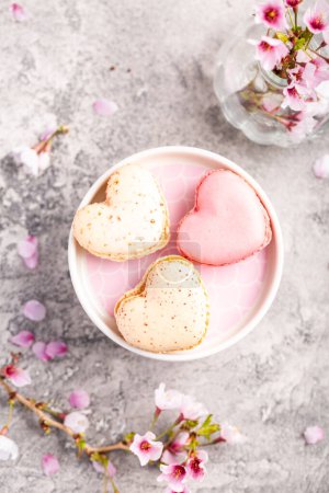 Téléchargez les photos : Macarons ou macarons français en forme de coeur avec branche de cerisier pour la fête des mères - en image libre de droit