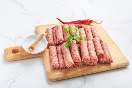 Téléchargez les photos : Saucisses de cevapi ou cevapcici serbes crues. Saucisses sans peau traditionnelles sud-européennes cevapcici à base de viande hachée et d'épices. - en image libre de droit