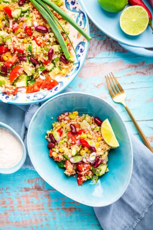 Téléchargez les photos : Salade mexicaine de quinoa aux tomates fraîches, concombres, oignons et coriandre - en image libre de droit
