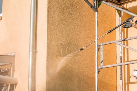 Téléchargez les photos : Lavage frontal de la maison, nettoyage avec un blaster à eau haute pression - en image libre de droit