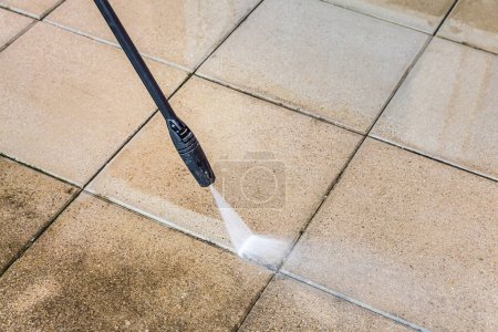 Photo for Detail of cleaning terrace with high-pressure water blaster, cleaning dirty paving stones - Royalty Free Image