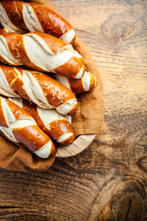 Foto de Palitos de pretzel y rollos de pretzel, pan de lejía bávaro con sal en una canasta - Imagen libre de derechos