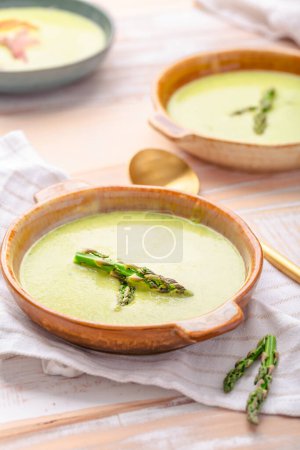 Photo for Creamy asparagus soup on wooden background - Royalty Free Image