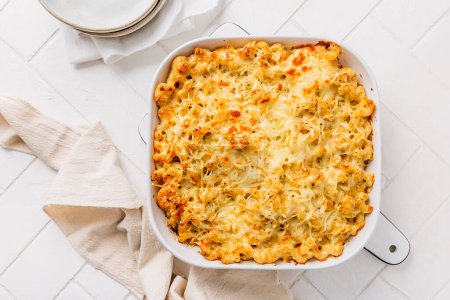Photo for Mac and cheese in casserole on white kitchen table - Royalty Free Image