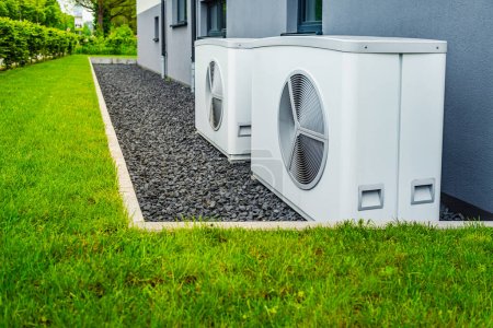 Zwei Luftquellen-Wärmepumpen außerhalb des neuen und modernen Stadthauses installiert, Konzept der grünen erneuerbaren Energien der Wärmepumpe