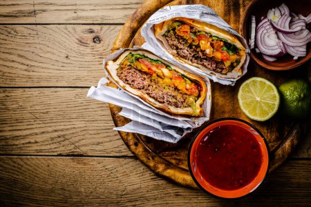Foto de Hamburguesa o sándwich, torta de res con salsa y guacamole. Cocina Mexicana. - Imagen libre de derechos