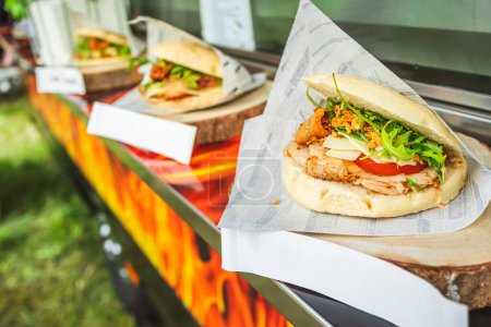 Foto de Bandeja con hamburguesas y hamburguesas variadas. Camión de comida en festival de comida callejera. - Imagen libre de derechos