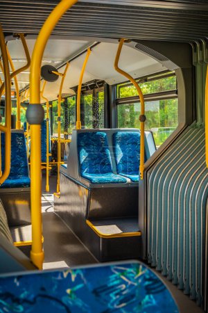Téléchargez les photos : Intérieur d'un bus de la ville. Intérieur vide du bus. Bus avec sièges bleus et mains courantes jaunes. Transports publics urbains. - en image libre de droit