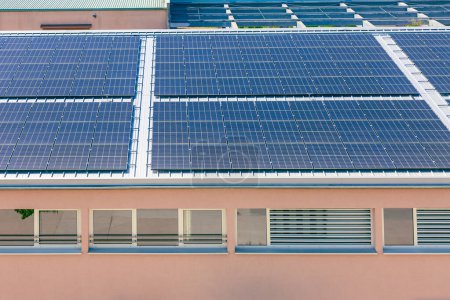 Foto de Paneles solares instalados en un techo de un gran edificio industrial o un almacén. - Imagen libre de derechos