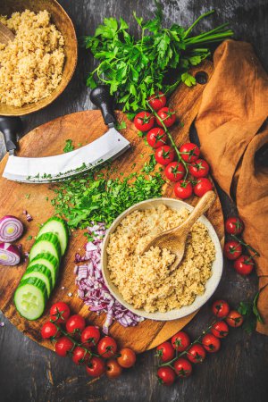 Photo for Preparing traditional oriental salad Tabouleh with couscous or bulgur, ingredients on cutting board - Royalty Free Image
