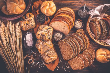 Photo for Assortment of different kind of cereal bakery - bread, pasties, buns, with healthy seeds on wooden background - Royalty Free Image