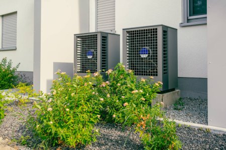 Téléchargez les photos : Pompes à chaleur à source d'air moderne installées à l'extérieur de la maison de ville neuve et moderne, concept d'énergie renouvelable verte de la pompe à chaleur - en image libre de droit