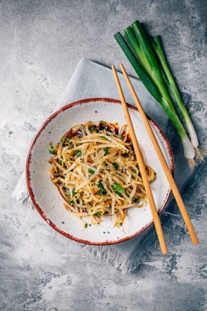 Photo for Korean bean sprout salad - spicy mung bean sprouts salad with garlic, sesame seeds, green onions and soy sauce - Royalty Free Image