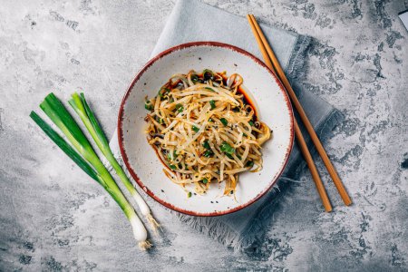 Photo for Korean bean sprout salad - spicy mung bean sprouts salad with garlic, sesame seeds, green onions and soy sauce - Royalty Free Image