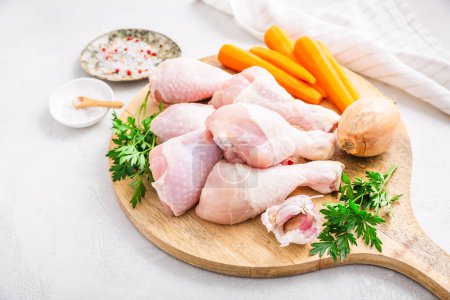 Photo for Raw chicken drumsticks with vegetables ans spices prepared for cooking - Royalty Free Image