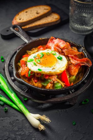 Téléchargez les photos : Letscho - savoureux ragoût de légumes hongrois aux poivrons, tomates et oignons, servi avec du bacon et des œufs frits - en image libre de droit