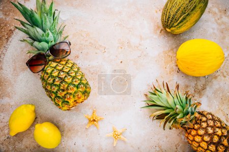 Téléchargez les photos : Concept d'été - Ananas hipster dans des lunettes de soleil avec melon et citrons, concept de vacances créatif art à la mode - en image libre de droit