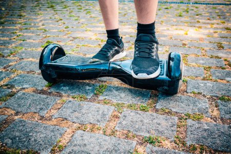 Teenager auf dem Hoverboard auf dem Schulhof - selbstbalancierender Roller, Schwebebrett für den persönlichen Transport