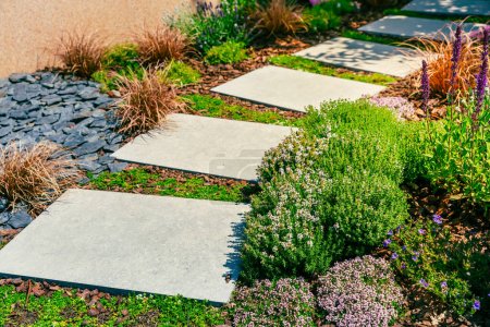 Photo for Detail of  garden path with stone slabs with bark mulch and native plants. Landscaping and gardening concept. - Royalty Free Image