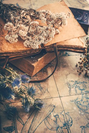Téléchargez les photos : Bouquets de fleurs sèches avec vieux journal et livres vintage, fond vintage nostalgique - en image libre de droit