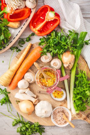 Photo for Homemade vegetable broth powder, organic vegetable stock, with raw vegetables, mushrooms and herbs - Royalty Free Image