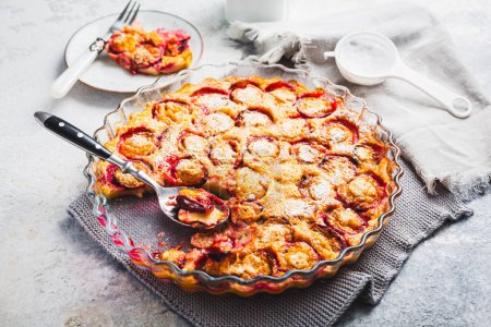 Téléchargez les photos : Flaugnarde ou Clafoutis - Dessert français aux prunes, grande crêpe cuite au four - en image libre de droit