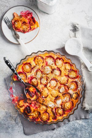 Téléchargez les photos : Flaugnarde ou Clafoutis - Dessert français aux prunes, grande crêpe cuite au four - en image libre de droit