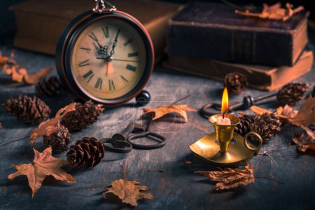 Téléchargez les photos : Nature morte vintage avec livres anciens, horloge et bougie. Halloween et concept occulte. - en image libre de droit