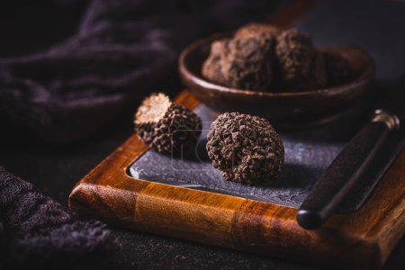 Photo for Expensive black truffles gourmet mushrooms  on kitchen table - Royalty Free Image