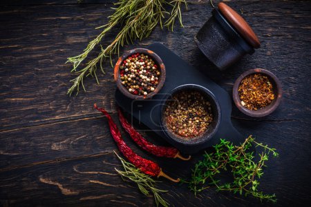 Photo for Cast iron spice mill for pepper, salt and herbs with ingredients - Royalty Free Image