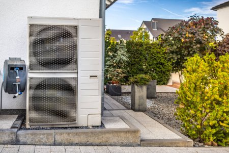 Téléchargez les photos : Deux pompes à chaleur à source d'air installées à l'extérieur de la maison familiale moderne, concept d'énergie renouvelable verte de la pompe à chaleur - en image libre de droit