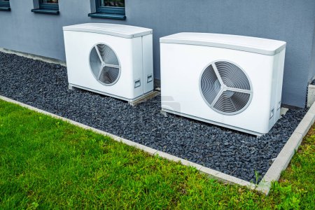 Two air source heat pumps installed outside of new and modern city house, green renewable energy concept of heat pump-stock-photo